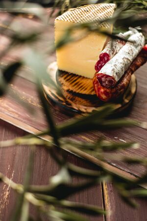 Cured Fuet chorizo, cheese, sausage from Spain. Salami sausage snack. Copy space. Wooden table background.の写真素材