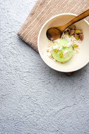 Homemade pistachio ice cream with white chocolate on old wooden table. Healthy food. Graphic resourceの写真素材