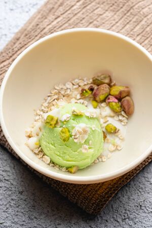 Homemade pistachio ice cream with white chocolate on old wooden table. Healthy food. Graphic resourceの写真素材