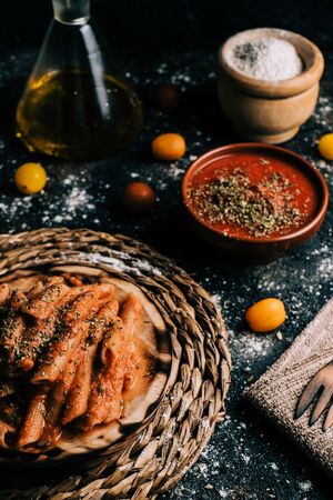 Penne. Homemade whole grain macaroni with tomato sauce on old wooden tableの写真素材