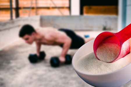 Protein shake Vanilla flavor accompanied by weights and sportsmen in the backgroundの写真素材