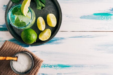 Refreshing drink with lime. Homemade mojito on summer wooden table surrounded by limes, peppermint and sugar. Copyspaceの写真素材