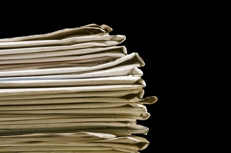 Pile of newspapers on black backgroundの写真素材