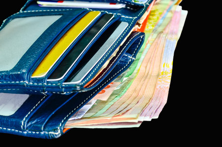 Wallet with money on black background