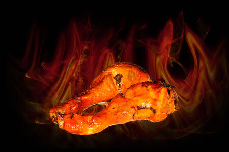 Grilled chicken legs on fire backgroundの写真素材