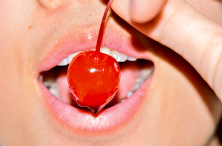 portrait of beautiful  with  red cherries in mouth