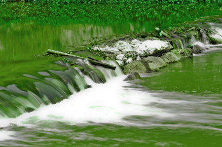 green water cascade on a riverの写真素材