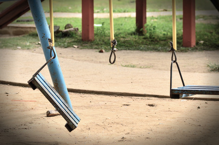 Old swing on children playground in vintage lightの写真素材