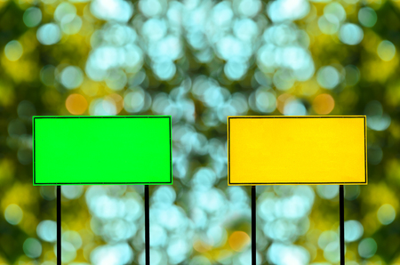 Green and yellow traffic road sign on green nature backgroundの写真素材