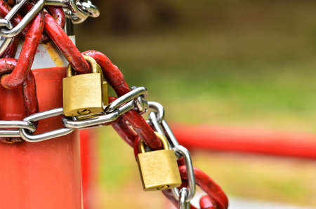 closed padlock with key and many chainsの写真素材