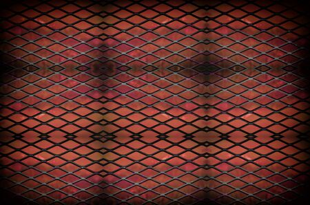 Old abstract metal grid pattern with red lighting effectの写真素材
