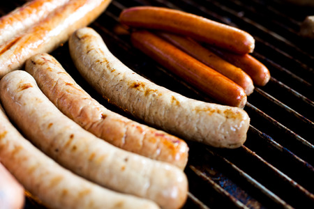 Several sausages grilled on the burnerの写真素材