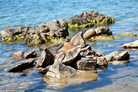 Stones with algae in deep blue seaの写真素材