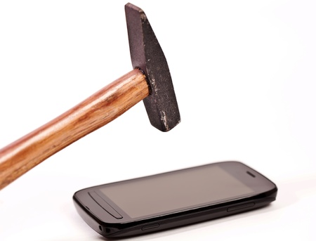 Hammer and phone on white background in attempt to brake monitorの写真素材