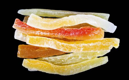 Dried papaya bars in sugar on black backgroundの写真素材