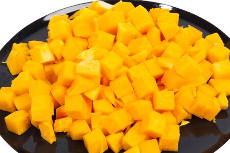 Orange tasty pumpkin blocks on black plateの写真素材