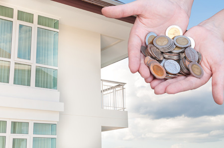 Coins in hands money Savings and apartment ,condominium,house,homeの写真素材