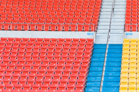 Empty orange and yellow seats at stadium,Rows of seat on a soccer stadiumの写真素材
