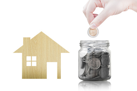 Hand putting coin into glass container of buying a new house - saving money for future concept,house savings coins. isolated on white backgroundの写真素材