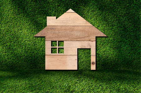 house icon from wooden texture on grass backgroundの写真素材