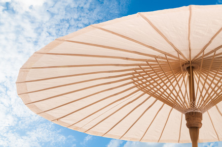 beautiful  Traditional Asian paper and bamoo umbrella with a rounded handle on blue skyの写真素材