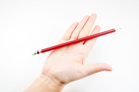 Red pencil  on hand woman on white backgroundの写真素材