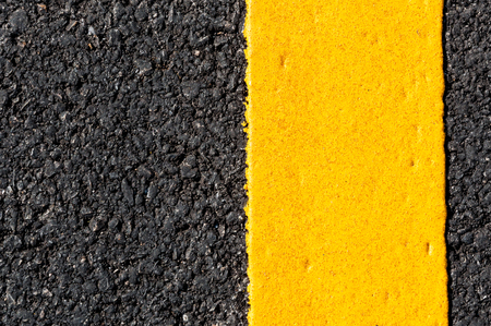 Yellow line on new asphalt detail,Street with yellow line textureの写真素材