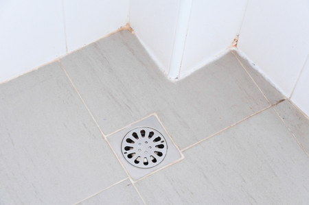 old chrome shower drain set in on a showerの写真素材