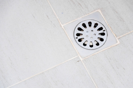 old chrome shower drain set in on a showerの写真素材