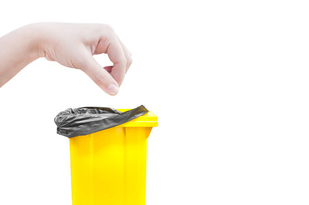 hand women Pick catch , yellow Garbage bins isolated on whiteの写真素材