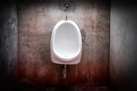 urinal on old concrete red wall,scary toiletの写真素材