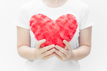 Woman holding and protecting a red heart shape on white background close-up,Symbol of love or dating Valentines dayの写真素材