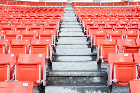 Empty orange seats at stadium,Rows of seat on a soccer stadiumの写真素材