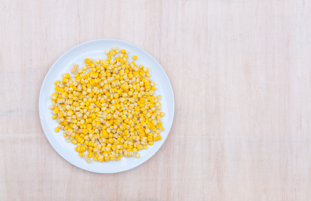 Sweet corn kernels in white dish on wooden backgroundの写真素材