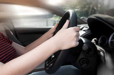 woman hand holding on black steering wheel, woman drive a carの写真素材