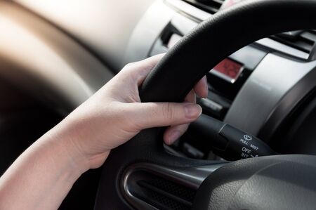woman hand holding on black steering wheel, woman drive a carの写真素材