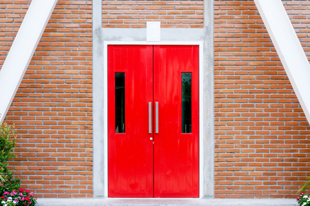 Red modern door with long stainless handle on brick wall at modern buildingの写真素材