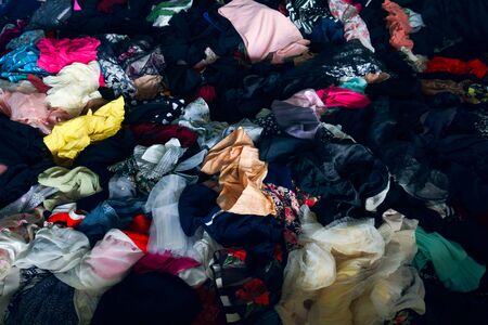 Pile of colorful clothes fabric,Lots of bright messy colorful clothing, abstract background.の写真素材