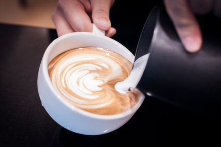 Hands pouring milk and preparing fresh cappuccino, coffee artist and preparation concept, Fresh morning coffee,coffee timeの写真素材