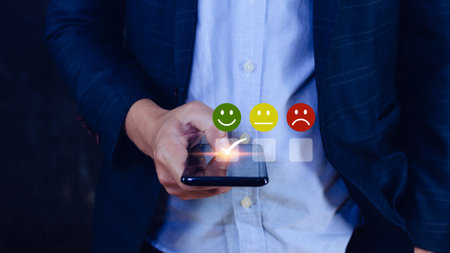 Businessman choosing happy smile face icon on SmartPhone. feedback rating and positive customer review experience, satisfaction survey. mental health assessment.の写真素材
