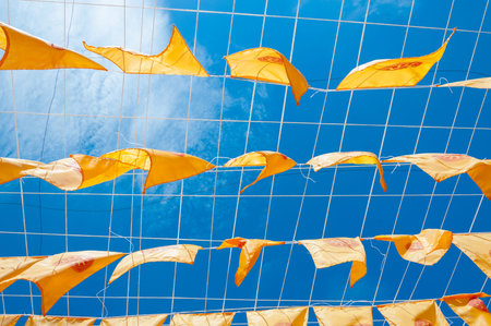 Thammachak flag yellow in temple (Wat Phan tao) on blue sky temple Northern Thailandの写真素材