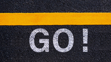 Word Go written on road in the middle of an empty asphalt road for business planning strategies and...