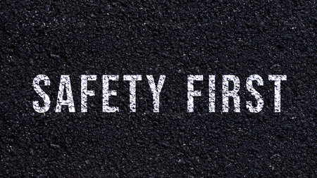 Safety first text written on the road in middle of the asphalt road, Safety first word on street.の写真素材