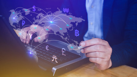 Businessman using mobile phone and laptop computer to money transfers and currency exchanges between...