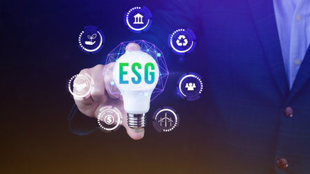 Businessman hand holding light bulb with ESG icon concept for environmental, social, and governance in sustainable and ethical business on the Network connection.の写真素材