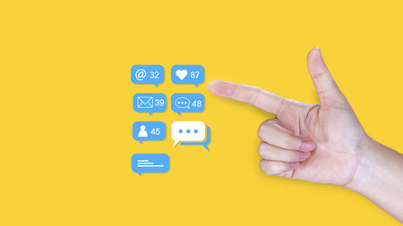 A hand pointing at social media interaction icons showing numbers for notifications, messages and...