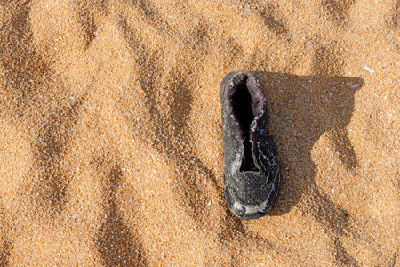 Garbage, shoes garbage the beach, sea water pollution with old shoes on sand in the beach, Environment and nature concept.の写真素材
