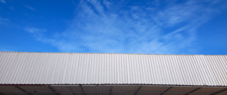 Metal sheet roof curve on blue sky. Modern construction, Metal ribbed arch span roof covering, Large...