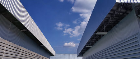 Metal sheet roof curve on blue sky. Modern construction, Metal ribbed arch span roof covering, Large building roof. not aiの写真素材