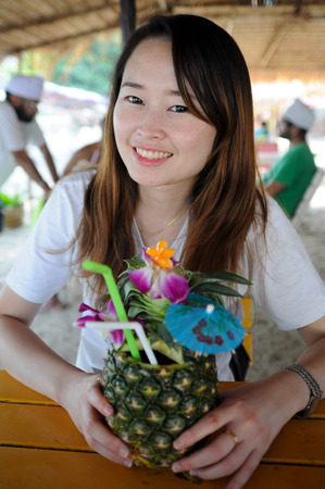 Young asian female drinking pineapple juiceの写真素材